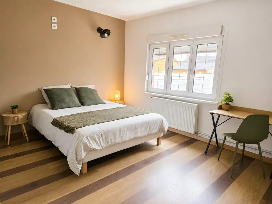 Chambre lumineuse avec grand lit double et coin bureau